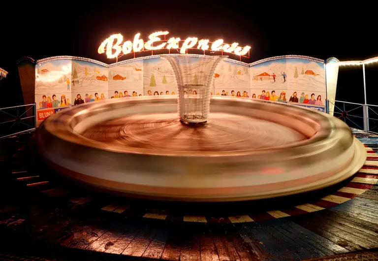 Leuchtender Bob Express in voller Fahrt bei Nacht auf dem Außengelände des Winterspektakels Hamburg