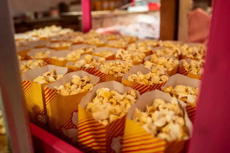 Reihen frisch gefüllter Popcorntüten am Stand Obstparadies